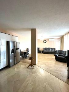 Una gran sala de estar con un sofá y un refrigerador. en Луксозен апартамент в сърцето на Сандански, en Sandanski