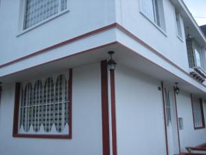 Hotel Casa Santa Marta في بوغوتا: مبنى ابيض وعليه خطوط حمراء وبيضاء