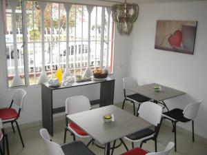 a restaurant with two tables and chairs and a window at Hotel Casa Santa Marta in Bogotá