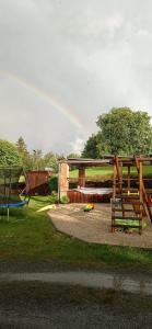 un parque con un parque infantil con una valla de madera en Apartments Cederika, en Věžovatá Pláně