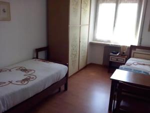 a bedroom with two beds and a window and a table at Warm, nice & amazing Lake-view apartment in San Zeno di Montagna