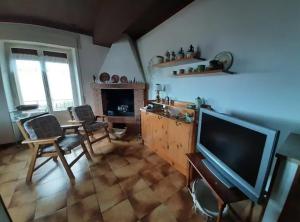 sala de estar con TV, mesa y sillas en Warm, nice & amazing Lake-view apartment, en San Zeno di Montagna