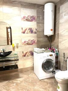 Un baño con lavadora y lavabo. en Луксозен апартамент в сърцето на Сандански, en Sandanski