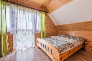 a bedroom with a bed and a large window at Osada Ostoja in Radziejowa