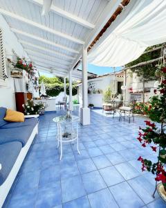 patio con pavimento piastrellato blu e pergolato bianco di La Bicocca di Annavì a Ischia