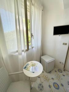 a small white room with a table and a window at La Bicocca di Annavì in Forio d'Ischia