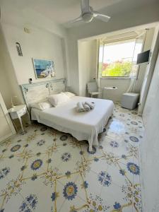 - une chambre avec un lit blanc et un sol bleu et blanc dans l'établissement La Bicocca di Annavì, à Ischia