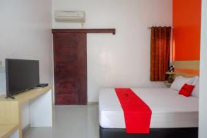 a room with a bed and a television in a room at RedDoorz Syariah near Alun Alun Kota Rembang in Rembang +36 photos