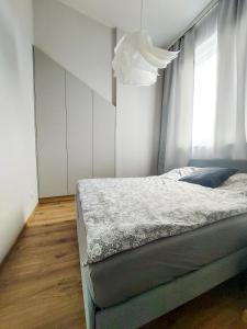 a bedroom with a bed and a chandelier at MR HOME APARTMENTS - Limba in Kraków