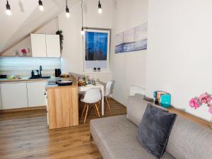 a living room with a couch and a small kitchen at MR HOME APARTMENTS - Limba in Kraków