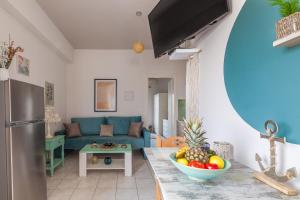 a living room with a couch and a bowl of fruit at Kissamos sea view beach apartments in Kissamos