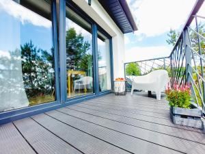 a deck with a table and chairs on a house at MR HOME APARTMENTS - Limba in Kraków