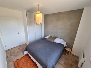 a small bedroom with a bed and a lamp at La Cabane de Jeanne ~ 10 minutes à pied de l'océan in Mimizan +9 photos