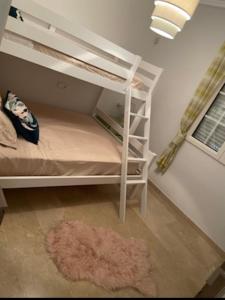 een wit stapelbed met een tapijt in een kamer bij Bungalow Los Dolses in Orihuela