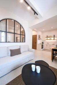 a living room with a white couch and a table at Plinthos Residence in Kavala