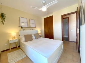 a bedroom with a large white bed in a room at Vistas al mar playa Eucaliptus, con solarium privado in L'Eucaliptus