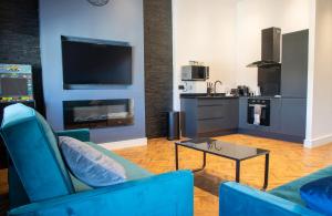 a living room with two blue chairs and a table at Withnell Stays - Apartment Six in Blackpool