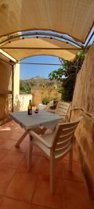 a table and chairs under an umbrella on a patio at Villa Bronja Studio airconditioned apartment Xlendi in Xlendi