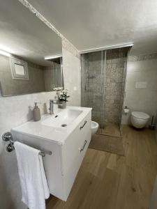 een witte badkamer met een wastafel en een toilet bij La Chicca in Ostuni