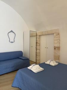twee bedden in een kamer met een spiegel bij La Chicca in Ostuni