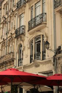 dois guarda-chuvas vermelhos em frente a um edifício em Casa Borges em Coimbra