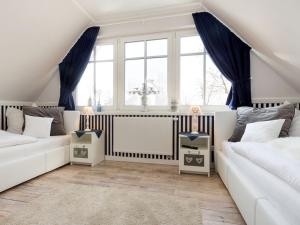 ein Wohnzimmer mit zwei weißen Sofas und einem Fenster in der Unterkunft Ostseezauber in Zingst
