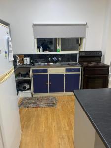 Marlo的住宿－Ralf's Coastal Shack，厨房配有蓝色橱柜和黑色台面