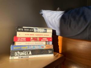 a stack of books sitting on top of a bed at Mountain Heart House in Bosanski Petrovac