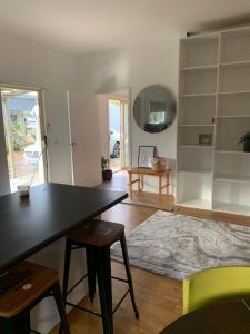 een woonkamer met een tafel en stoelen en een spiegel bij Ralf's Coastal Shack in Marlo