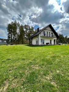 a house on a field with a large grass field at Gościniec Wigry 1 in Walne