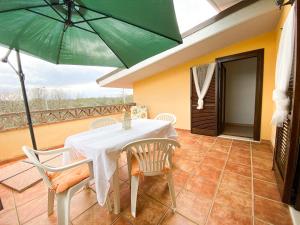 a table and chairs with a green umbrella on a balcony at Sole Luna in Ortona