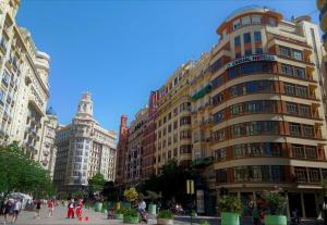 un edificio alto con gente caminando delante de él en Casual Vintage Valencia, en Valencia