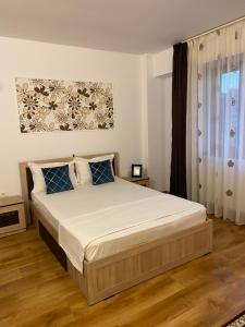 1 dormitorio con 1 cama grande con almohadas azules en Vila Hestia, en Constanţa