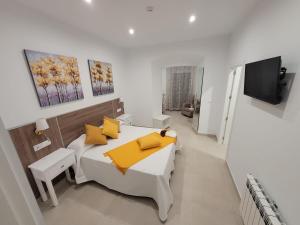 a bedroom with a white bed with yellow pillows at Casa Rural "Laplaza23" in Herrera del Duque