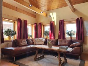 a living room with a brown leather couch and a table at Ferienwohnung Rabus in Bisingen