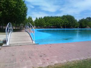 a wooden boardwalk leading to a large swimming pool at Villa de Castro in Villar de los Barrios