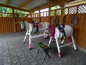 two white horses standing next to a bowl of fruit at Bei Schütts - Spiel und Spaß im Garten rund um eine moderne Ferienwohnung in Janneby