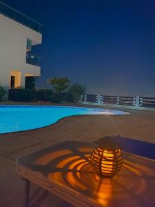 a lit candle sitting on a table next to a swimming pool at 3 Bedroom Seaview Villa direct in Coral Bay with Pool in Coral Bay