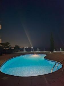 uma grande piscina azul à noite com um arco-íris em 3 Bedroom Seaview Villa direct in Coral Bay with Pool em Coral Bay