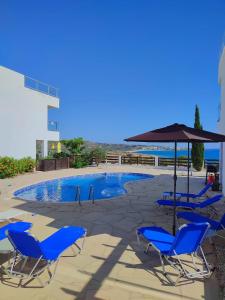 a group of chairs and an umbrella next to a swimming pool at 3 Bedroom Seaview Villa direct in Coral Bay with Pool in Coral Bay