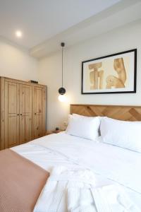 a bedroom with a white bed and a picture on the wall at Plinthos Residence in Kavala