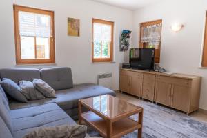 a living room with a couch and a tv at House Parabola in Log pod Mangartom