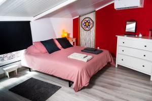 リスボンにあるCasa do Sol - Av da Liberdade - Rossio - Lisboaのピンクベッドと赤い壁が備わるベッドルーム1室が備わります。