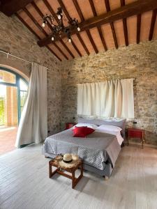 a bedroom with a large bed in a stone wall at Agriturismo La Fontanella & Glamping in Suvereto