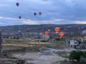 un gruppo di mongolfiere che volano sopra una città di Ala Stone Hotel a Göreme