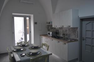 kuchnia ze stołem, krzesłami i zlewem w obiekcie Casa giulia w mieście Ostuni