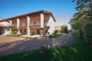 a large house with a brick driveway in a yard at B&B Cascina Quaderna in Castenedolo