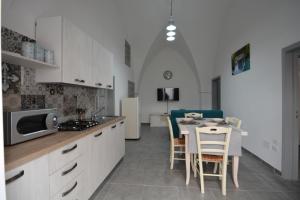 uma cozinha e sala de jantar com mesa e cadeiras em Casa giulia em Ostuni
