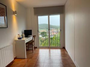 a room with a desk with a computer and a window at Smallville - Sitges Apartamento independiente para 4 personas con piscina in Sant Pere de Ribes