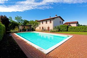 a swimming pool in front of a house at B&B Cascina Quaderna in Castenedolo